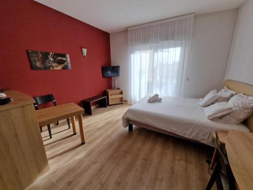 um quarto com uma cama, uma secretária e uma janela em Appartement confortable - Proche du lac em Divonne-les-Bains