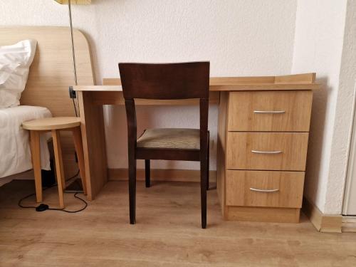 un escritorio de madera con una silla junto a una cama en Appartement confortable - Proche du lac, en Divonne-les-Bains