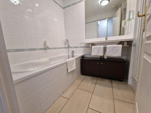 uma casa de banho com uma banheira e um lavatório e uma banheira em Appartement confortable - Proche du lac em Divonne-les-Bains
