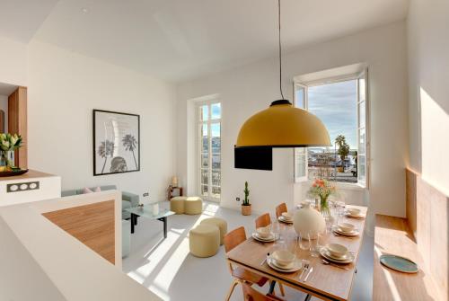 un salon avec une table et une salle à manger dans l'établissement IMMOGROOM - Appartements luxueux - 2min du Palais - Vue mer - Clim, à Cannes