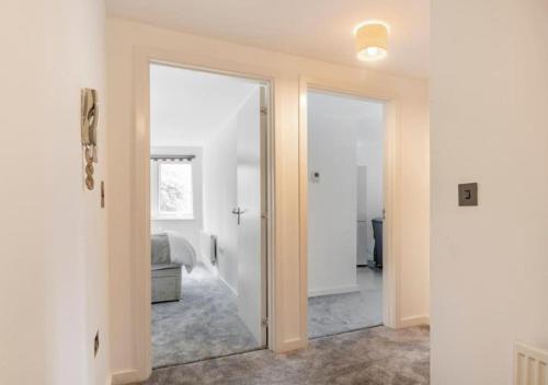 a hallway with a mirror and a room with a bed at The Dartford Lodge - Free Parking in Kent