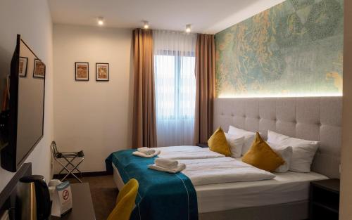 um quarto com uma cama grande e almofadas amarelas em Trip Inn Boutique Messe Frankfurt em Frankfurt