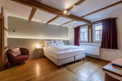 um quarto com uma grande cama branca e uma cadeira em DAS HOCHREIN em Volkach
