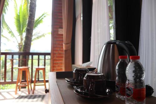 a table with a tea kettle and cups on it at Abing Dalem - Villa Nangka in Tabanan