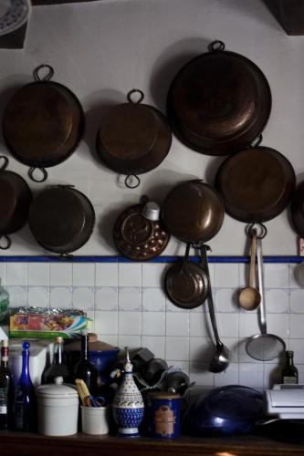 a bunch of pots and pans hanging on a wall at Podere Badia Valdrago Agriturismo Mugello Circuit in Scarperia