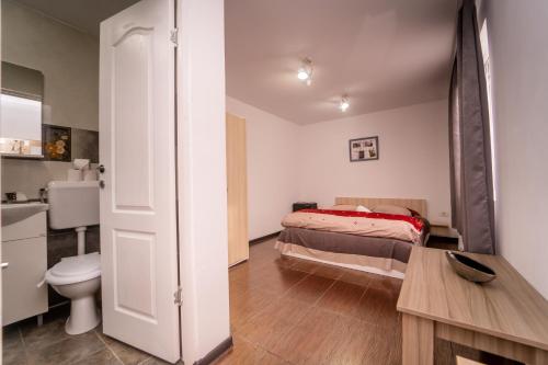 a small bedroom with a bed and a toilet at Complex Route 66 in Vama Veche