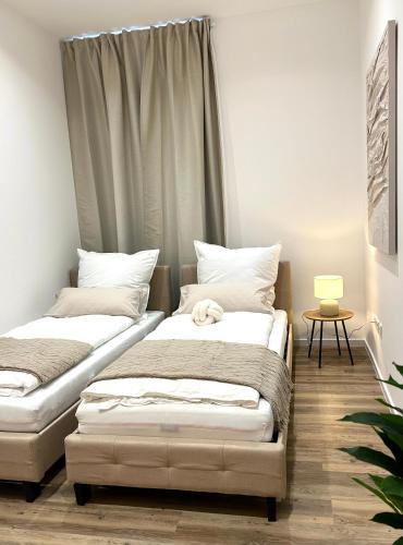 two beds sitting next to each other in a room at Designer City Apartment in Top Lage für 6 Gäste in Karlsruhe