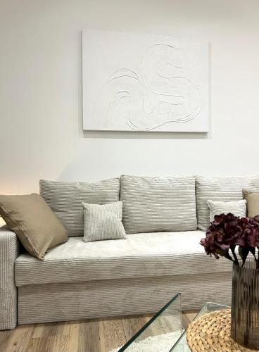 a living room with a couch and a painting on the wall at Designer City Apartment in Top Lage für 6 Gäste in Karlsruhe