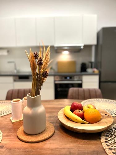 a table with a plate of fruit and a vase with flowers at Designer City Apartment in Top Lage für 6 Gäste in Karlsruhe
