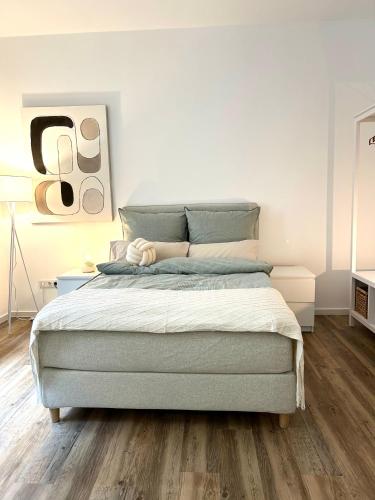 1 dormitorio con 1 cama grande y suelo de madera en Designer City Apartment in Top Lage für 6 Gäste en Karlsruhe