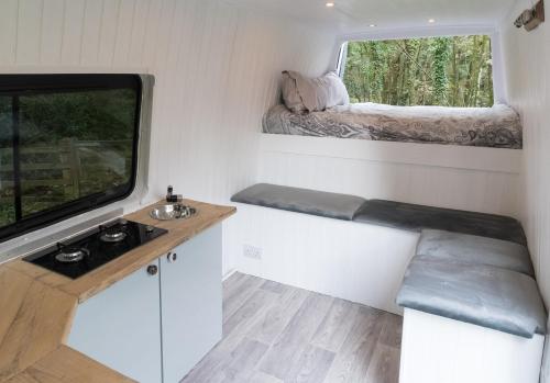 Habitación pequeña con lavabo y ventana en Viv The VW Campervan - Drive Away, en Neath