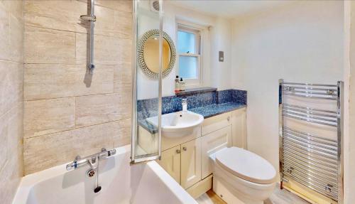 ein Badezimmer mit einer Badewanne, einem WC und einem Waschbecken in der Unterkunft Bright & Spacious West London Gem in London