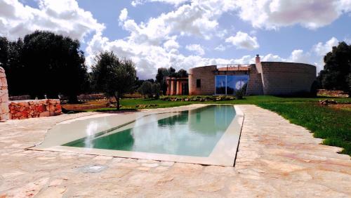a swimming pool in front of a building at trullo contemporaneo in Serranova
