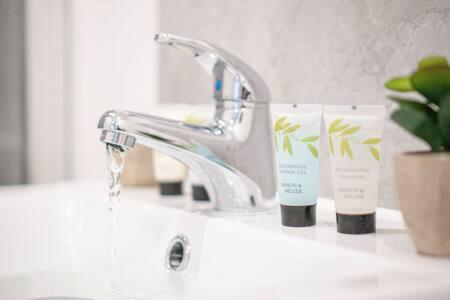 a bathroom sink with a faucet and two toothbrushes at Stylish 1 Bed Apartment in Wolverhampton in Wolverhampton