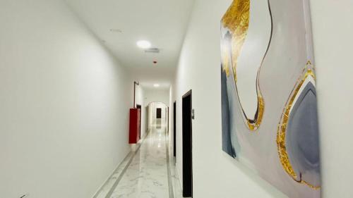 a hallway in a building with paintings on the walls at Haima Hotel in Haymāʼ