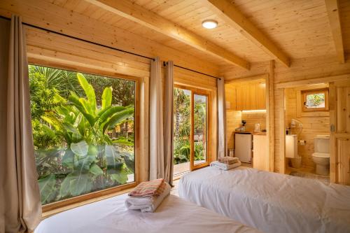 - une chambre avec 2 lits et une grande fenêtre dans l'établissement Garden bungalow, à São Vicente