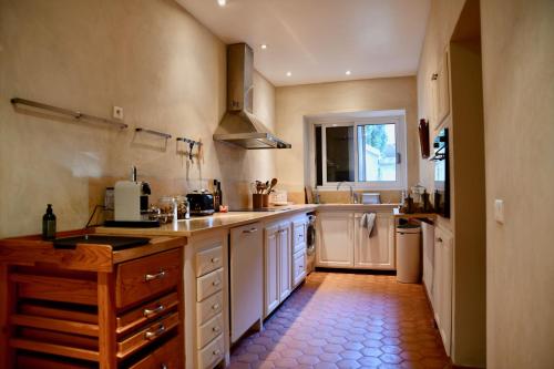 una grande cucina con armadi bianchi e una finestra di La Maison du Mas de Peint a Arles