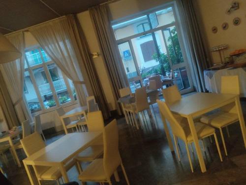 a dining room with tables and chairs and windows at Hotel Caporal in Minori