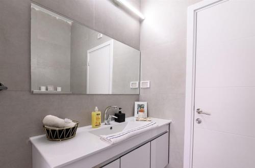 uma casa de banho com um lavatório e um espelho em וילת אורית בגלבוע 