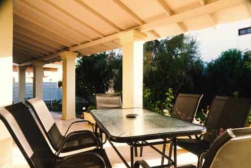 een tafel en stoelen op een terras bij Dada's Cottage in Argyrádes