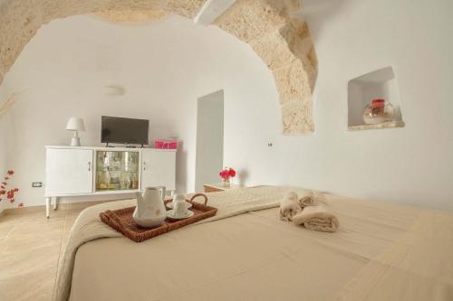 een slaapkamer met een bed in een kamer met een boog bij Trullo Mimosa by Perle di Puglia in San Michele Salentino