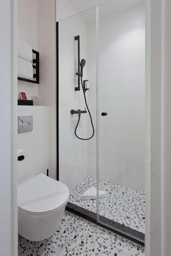 une salle de bain avec une douche en verre et des toilettes dans l'établissement Trendy Canettes Hotel, à Paris