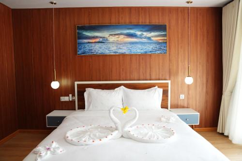 a bedroom with a bed with two swans on it at One Beach Resort By EHM in Koh Rong Sanloem