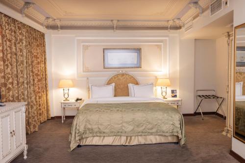 ein Schlafzimmer mit einem großen Bett und zwei Tischen in der Unterkunft Anemon Galata Hotel in Istanbul