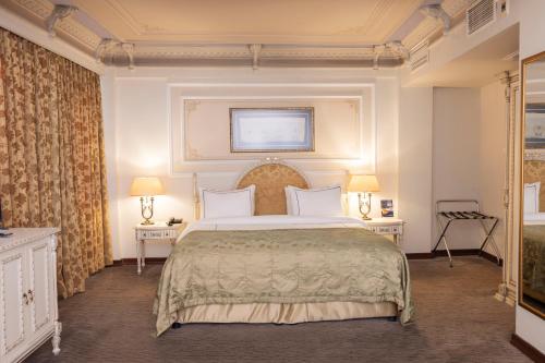 ein Schlafzimmer mit einem großen Bett und zwei Tischen in der Unterkunft Anemon Koleksiyon Galata Otel in Istanbul