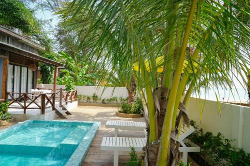 a patio with a pool and a palm tree at One Beach Resort By EHM in Koh Rong Sanloem