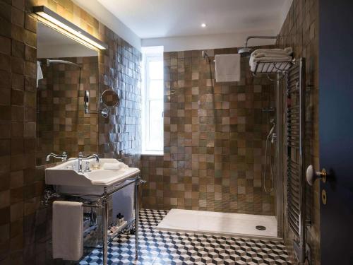 uma casa de banho com um lavatório e um chuveiro em Hôtel & Spa Jules César Arles - MGallery Hotel Collection em Arles