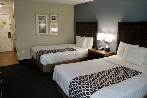 a hotel room with two beds and a telephone at La Quinta by Wyndham Tomball in Tomball
