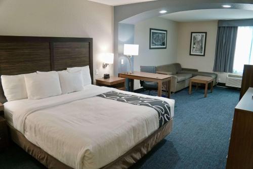 une chambre d'hôtel avec un grand lit et un salon dans l'établissement La Quinta by Wyndham Tomball, à Tomball