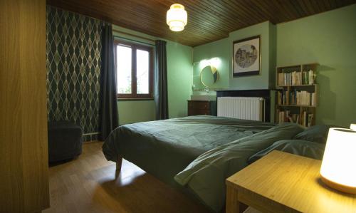 une chambre verte avec un lit et une fenêtre dans l'établissement La Maison Romanaise, à Romans-sur-Isère