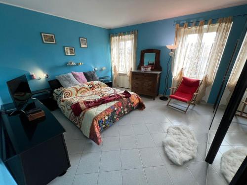 a blue bedroom with a bed and a red chair at Allegra in Verbania