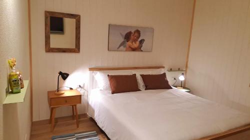 - une chambre avec un lit blanc et un miroir dans l'établissement Appartamento Belvedere, à Dubino