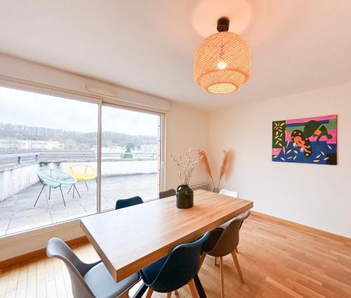 une salle à manger avec une table et des chaises et une fenêtre dans l'établissement La Douce Évasion à 13 minutes du château de Versailles, à Saint-Cyr-lʼÉcole