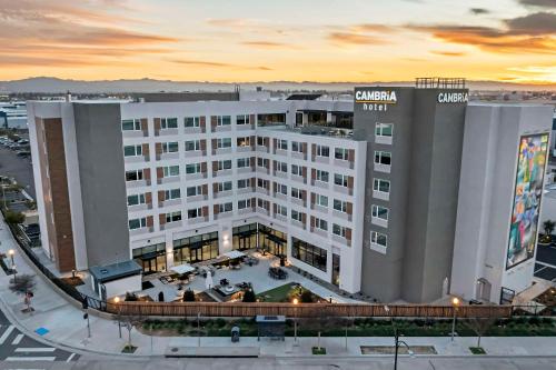 a large white hotel with a sunset in the background at Cambria Hotel Burbank Airport in Burbank