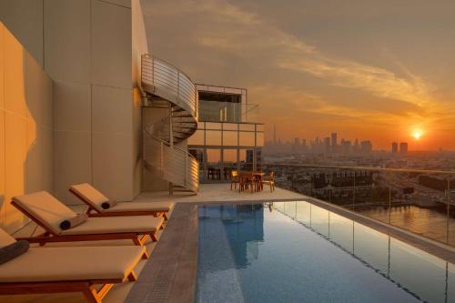 a pool on the roof of a building with a view at Hilton Dubai Creek Hotel & Residences in Dubai