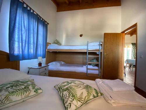 a bedroom with two bunk beds with blue curtains at Arrifana Beach Break in Aljezur