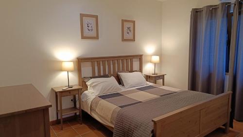 1 dormitorio con 1 cama con 2 mesas y 2 lámparas en Quinta da Pedra Mija, en Santar