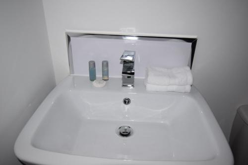 La salle de bains est pourvue d'un lavabo blanc et d'un miroir. dans l'établissement 7 Plants Yard, à Worksop