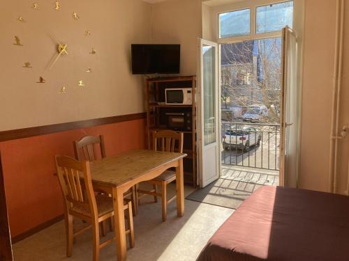une salle à manger avec une table et des chaises et une fenêtre dans l'établissement Hotel Victoria, à Saint-Pierre-de-Chartreuse