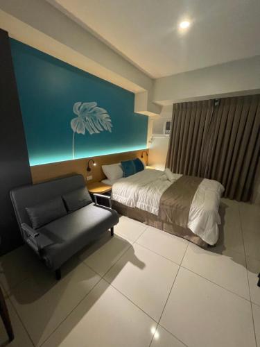 a hotel room with a bed and a chair at MG’s PLACE at Horizons 101 in Cebu City