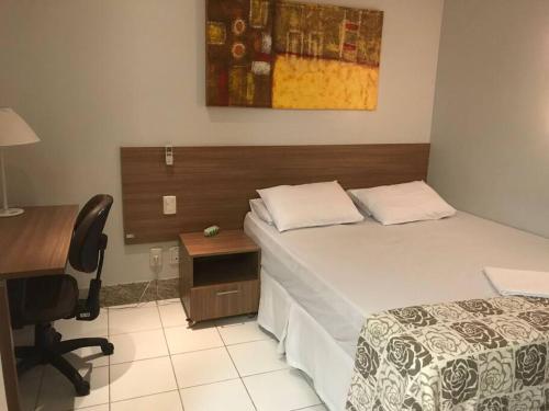 a bedroom with a bed and a desk and a chair at Sun Square Marista Vista Pça do Sol! Hospitais,mercados e cartórios, tudo perto! 301 in Goiânia