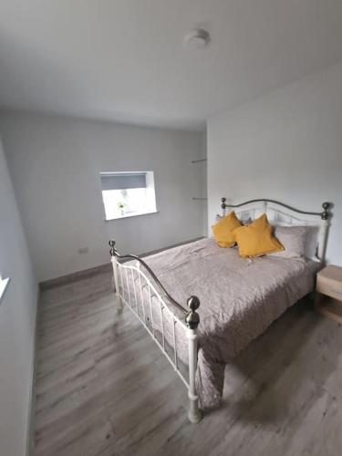 a bedroom with a bed with yellow pillows on it at Welcome to DC's Cottage in Holycross