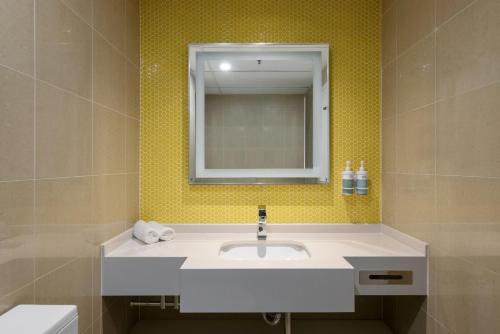 a bathroom with a sink and a mirror at Sydney Central Hotel managed by The Ascott Limited in Sydney