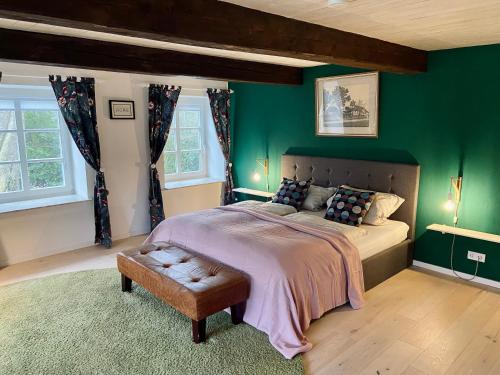 a bedroom with a large bed with green walls at Ferienhaus Tante Elses - Ruhe & Erholung zwischen den Meeren - gemütliche & stilvolle Ausstattung in Süderhöft
