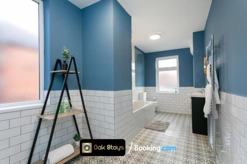 baño con paredes azules, bañera y lavamanos en Fosse Road North By Oak Stays Short Lets & Serviced Accommodation Leicester With Free WiFi en Leicester