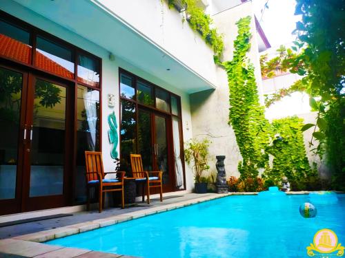 a pool with two chairs next to a building at 3Bedroom Villa Kepiting Sanur in Sanur
